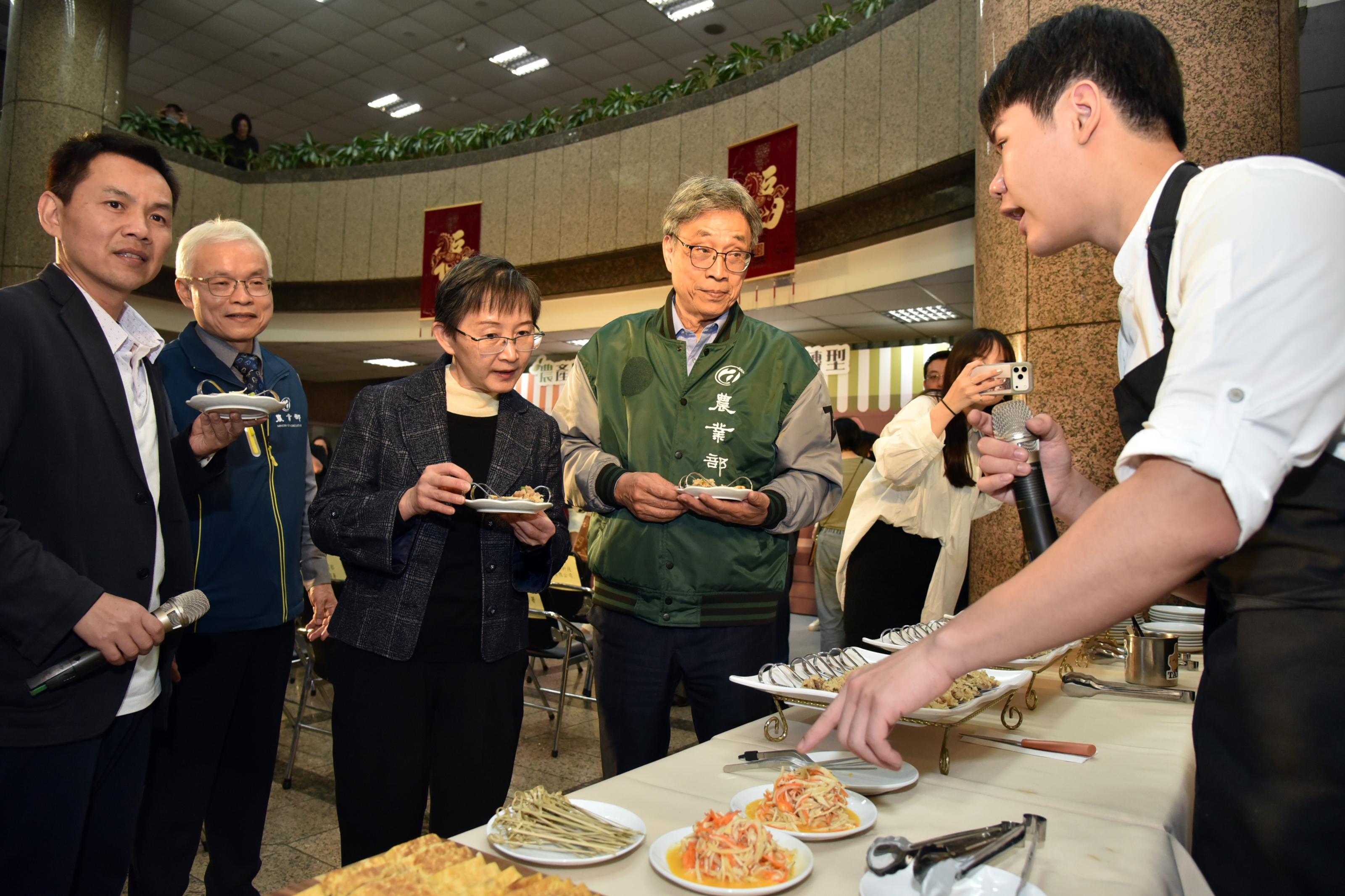 圖7_農業部陳駿季部長、資源永續利用司的莊老達司長與環境部陳淑玲主任秘書、氣候變遷署張根穆副署長，聽著首惜廚師介紹碳足跡料理並品嘗碳足跡農產製作的料理