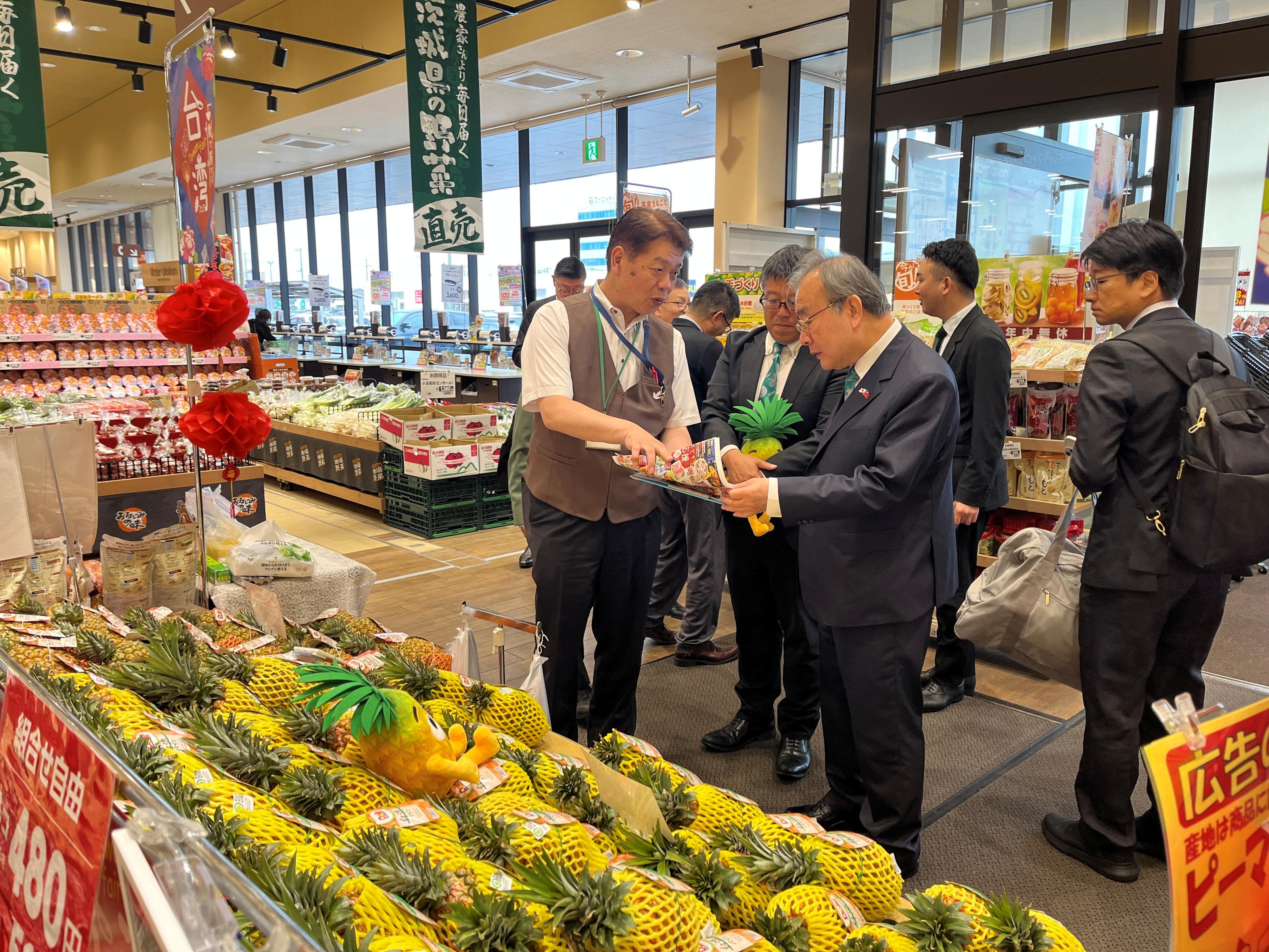 照片4_超市水戶元吉店中田厚志店長（左）在訪視臺灣鳳梨銷售時，向農業部胡忠一次長（右）介紹芒果鳳梨行銷策略。