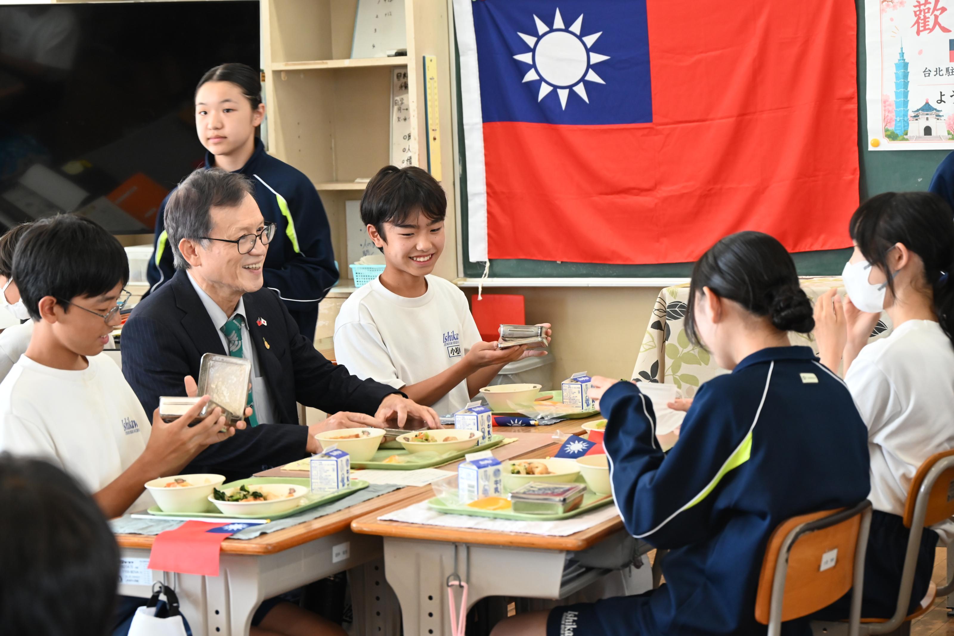 圖片3_駐日本代表處王清要組長與學生代表共同享用營養午餐，並向學生介紹臺灣芒果特色。