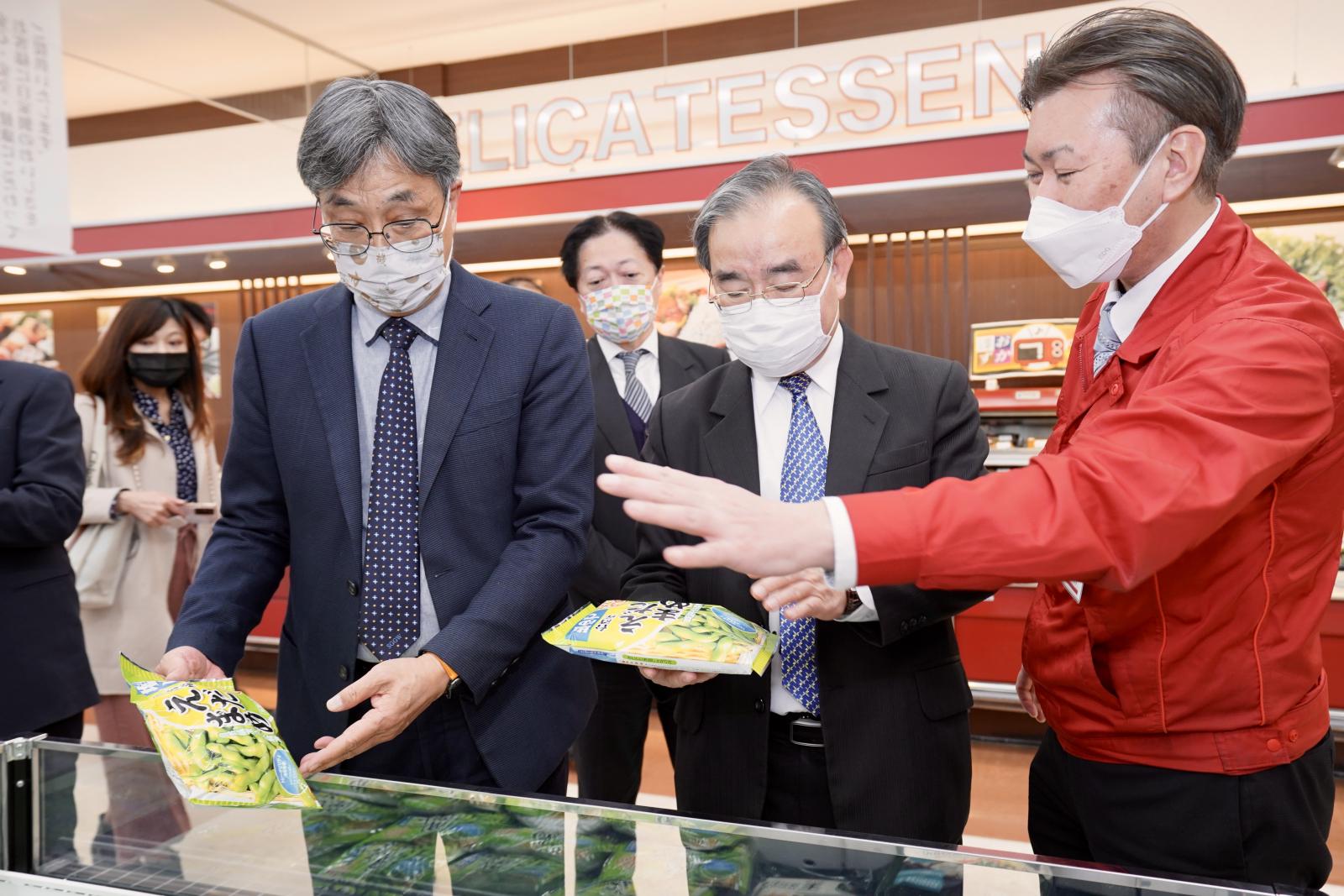 olympic超市人員向陳駿季副主委等人展示該超市門市販售臺灣冷凍毛豆