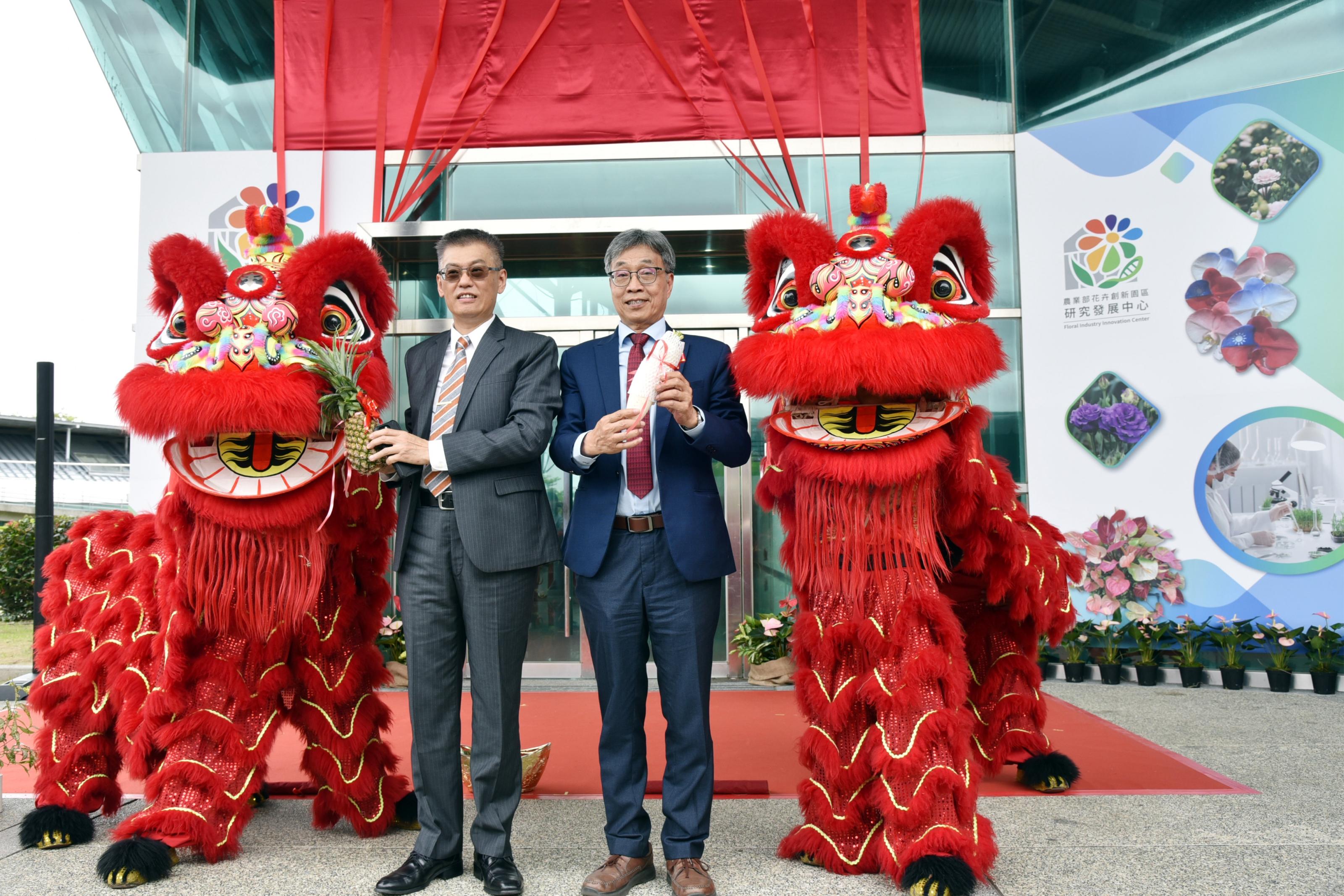 農業部陳駿季部長與花創中心戴廷恩主任手持菜頭及鳳梨,象徵好彩頭