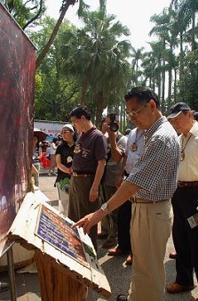 陳主委武雄在藝文森林攤位,逐字逐句欣賞與自然森林相關的詩詞創作。