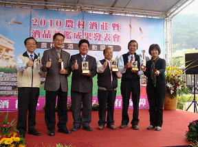 圖1 陳主任委員頒發2010年酒品評鑑金牌獎獎座，表揚大湖地區農會「草莓淡酒」、埔里鎮農會「玫瑰淡酒」及車埕酒莊「鐵軌」等3款獲獎酒品