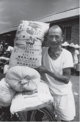 01 1950 年代美國曾捐贈大批麵粉給臺灣，農民領取美援麵食時充滿著喜悅 