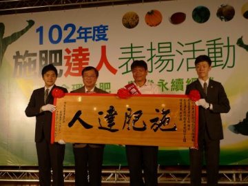 萬班長（右 2 ）榮獲 102 年度施肥達人殊榮，由陳主委保基（左 2 ）親頒匾額以茲表揚 