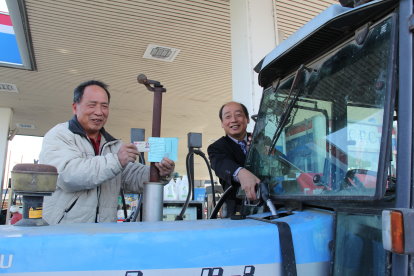 農糧署李署長蒼郎 ( 右 ) 與農民共同示範農機用油作業資訊化 